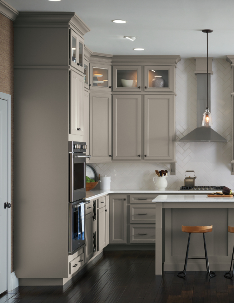 Beige wooden cabinets in neutral kitchen with barstool seating. 