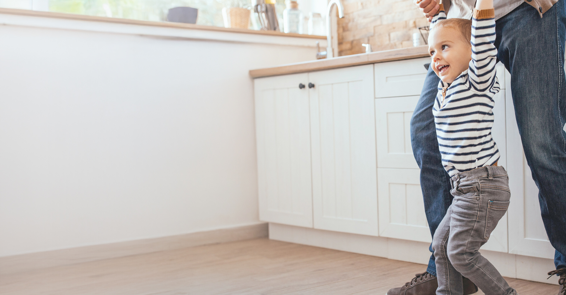 Woman sitting on a hardwood floor with a coffee mug in her hand.
